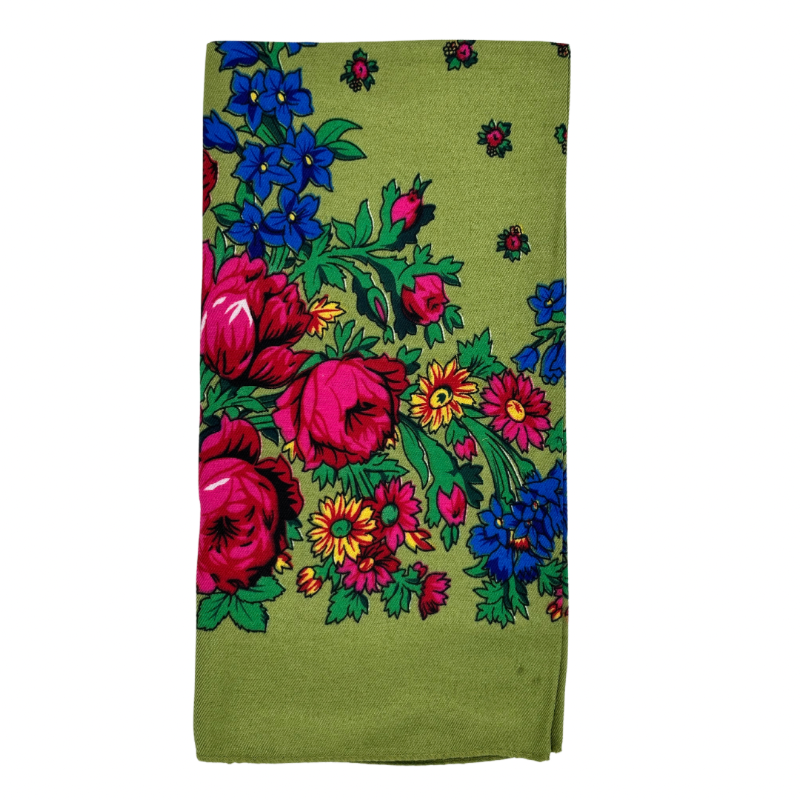 A light green scarf with a floral pattern, including large pink and blue flowers, folded neatly.