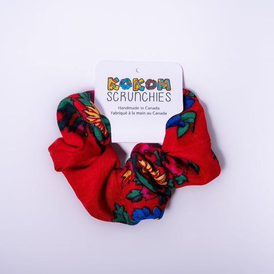 Red scrunchies with colorful patterns on a white background, featuring a 'Kokom Scrunchies' label.