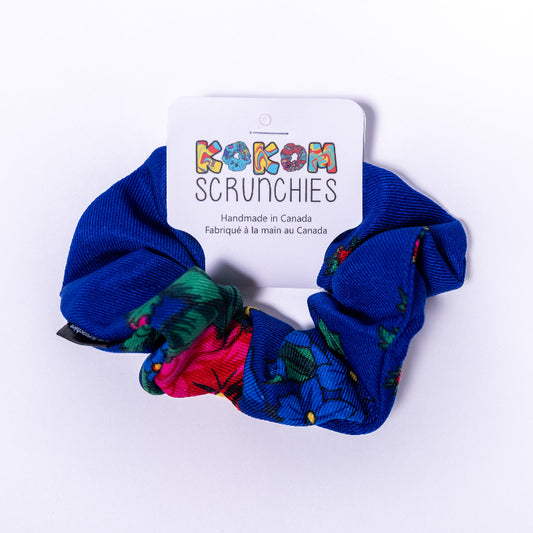blue scrunchie with floral patterns on a white background, featuring a Kokom Scrunchies label.