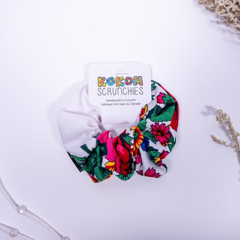 Colorful scrunchie with floral pattern on a white background, featuring 'Kokom Scrunchies' branding.