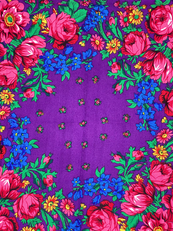Purple fabric with colorful floral pattern on a purple background