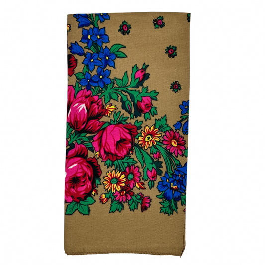 A light brown scarf with a floral pattern, including large pink flowers and green leaves.