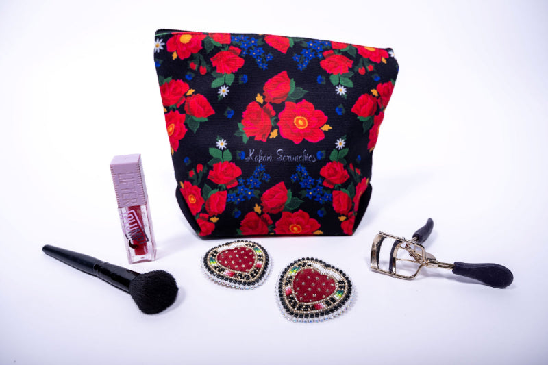 Floral makeup bag with cosmetic items on a white background