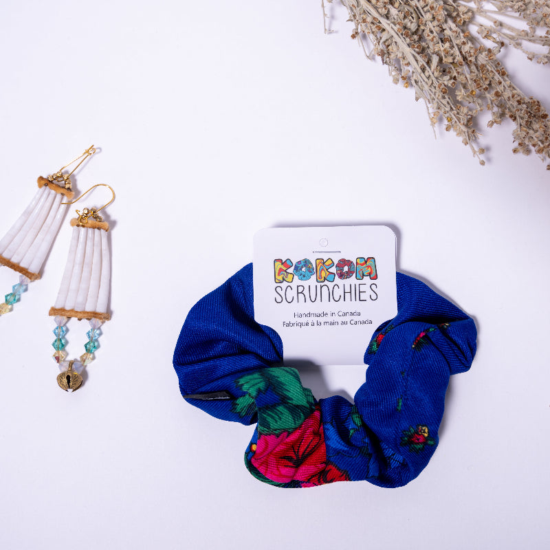 Blue scrunchie with floral patterns next to a card displaying 'KOKOM Scrunchies' on a white background.