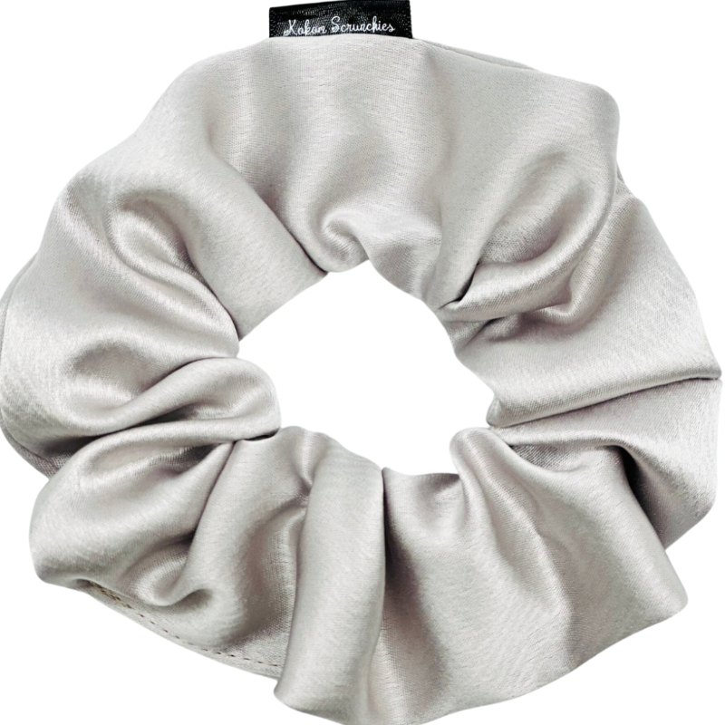 A gray satin scrunchie displayed on a neutral background.