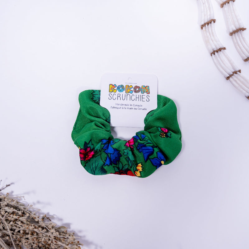 Green scrunchie with floral pattern on a white background, featuring a 'Kokom Scrunchies' label.